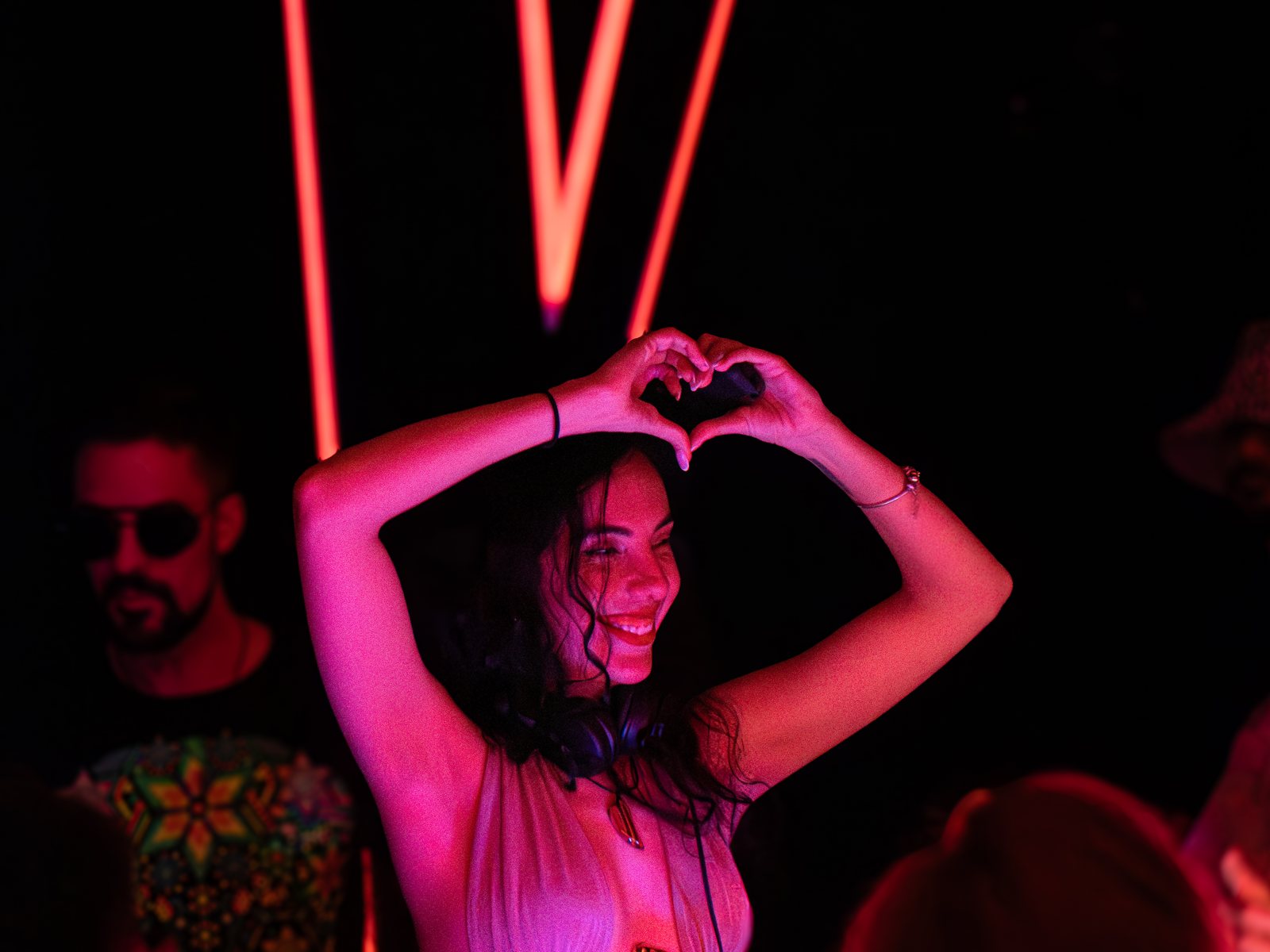 A dancer making a heart shape with her hands on the dance floor