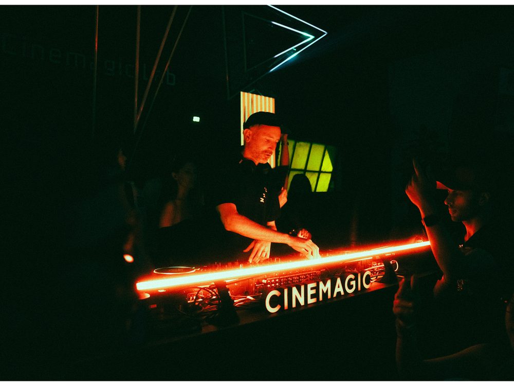 DJ playing behind the glowing CINEMAGIC booth